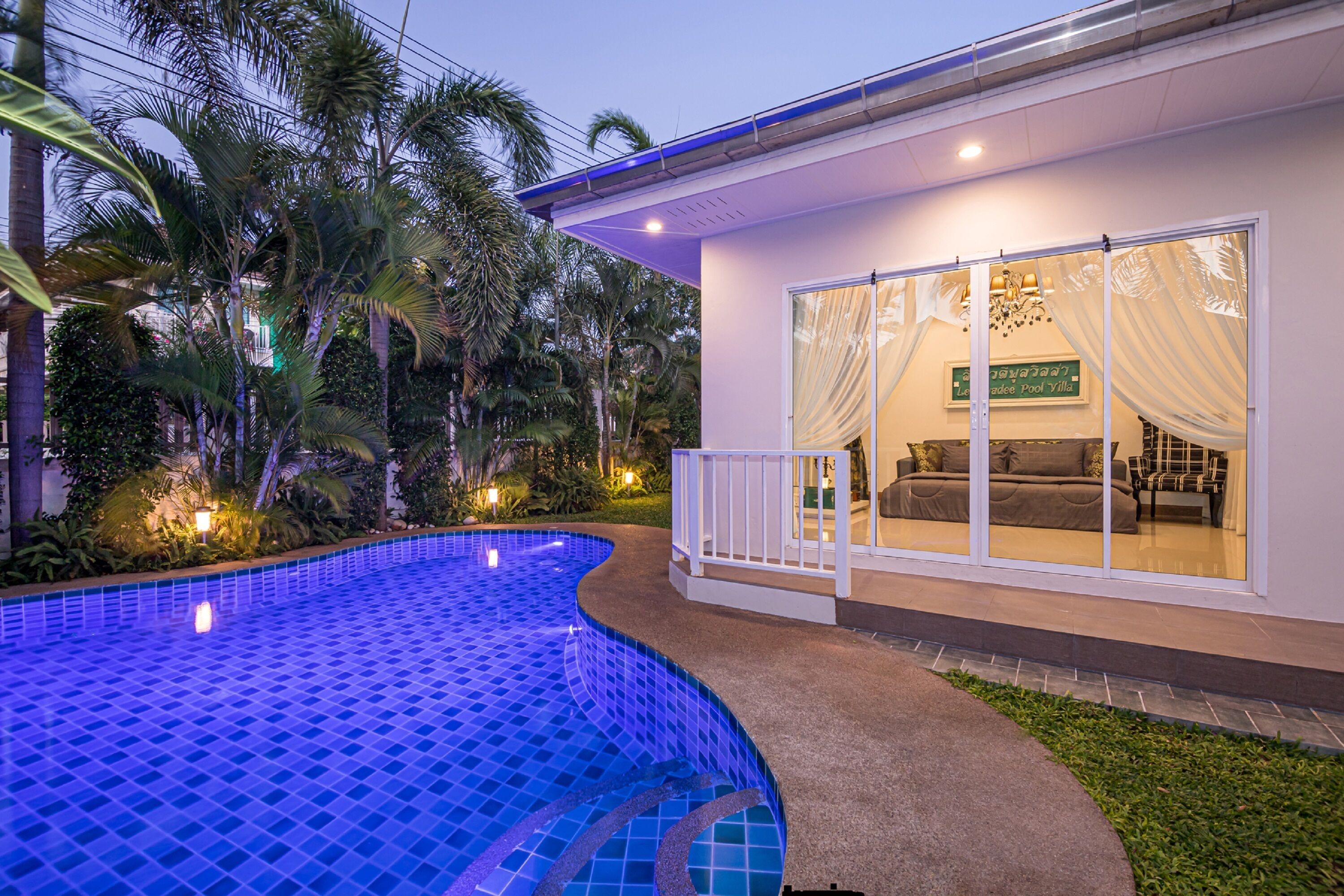 A poolside area with a curved pool, a covered seating area with a sofa and chairs, and a sign indicating 'Le Meridie Pool Villa'.