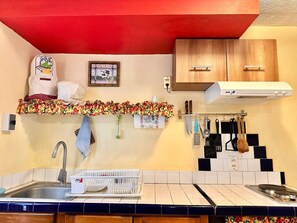 A kitchen with a sink, a white dish rack, a red ceiling, and wooden cabinets. - Nice apartment, equipped near the Malecon and the beach (La Paz)