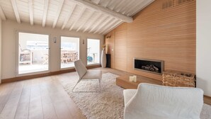 A spacious living room with a high ceiling, large windows, a fireplace, and a view of the outdoors. - Penthouse Hilife Panoramic Terrace (Florence)