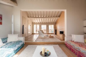 A spacious living room with a high ceiling, a sofa set, a coffee table with candles, and a view through an open door to a balcony. - Penthouse Hilife Panoramic Terrace (Florence)