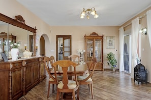 A dining area with a wooden table, chairs, and a cabinet.