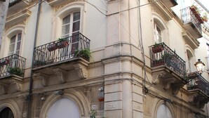 A historic building with ornate balconies, large windows, and a prominent entrance.