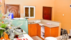 Une cuisine de taille réduite, avec des meubles de rangement en bois, un plan de travail et un évier.