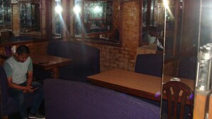 L’intérieur d’un restaurant avec des murs en briques, des meubles en bois et des unités de climatisation.