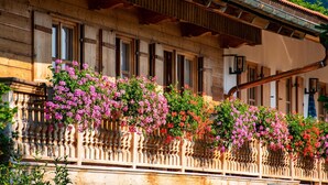 A wooden building with a balcony adorned with flowering plants.