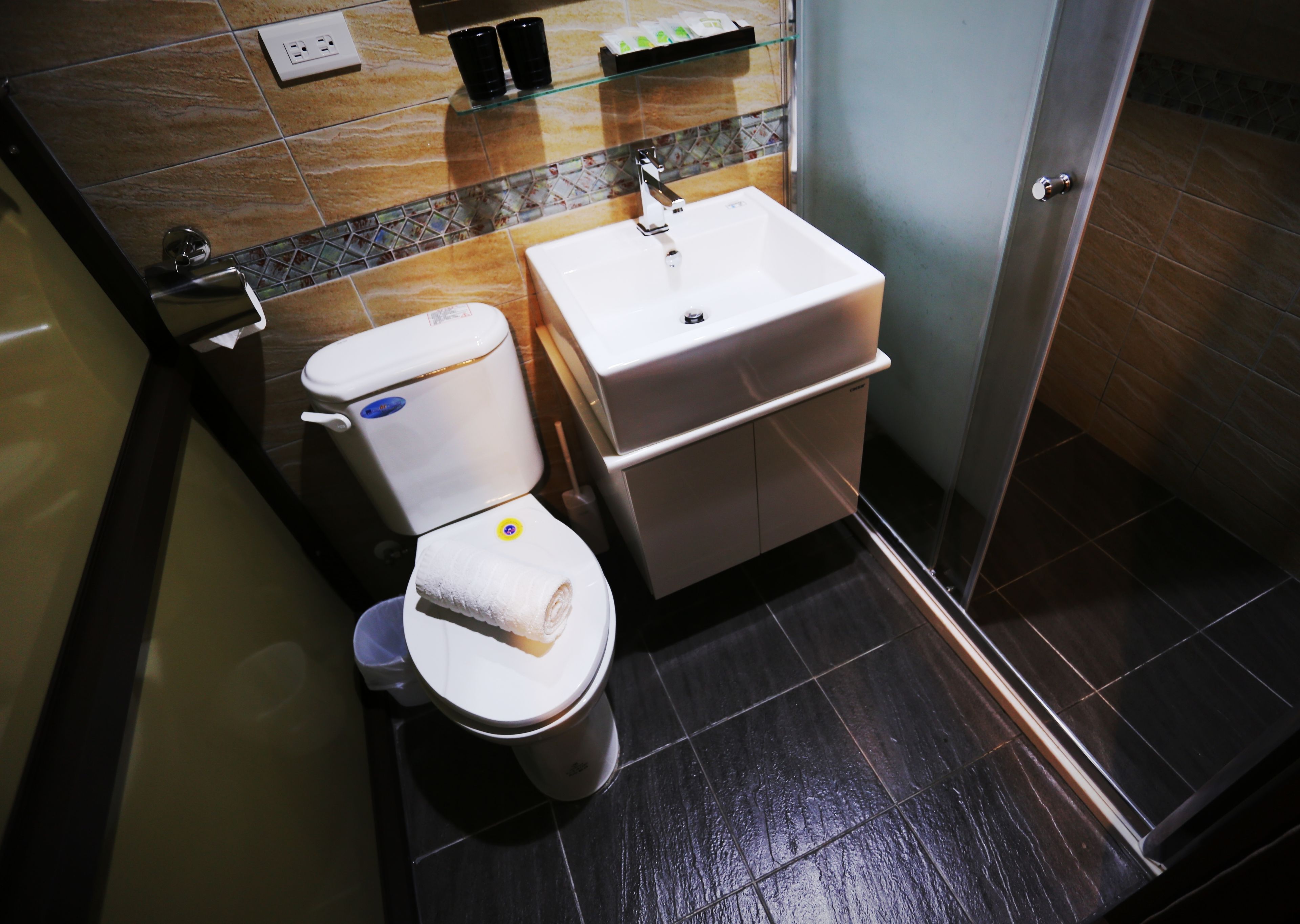Ein modernes Badezimmer mit Toilette, Waschbecken und Dusche.