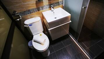 Ein modernes Badezimmer mit Toilette, Waschbecken und Dusche.