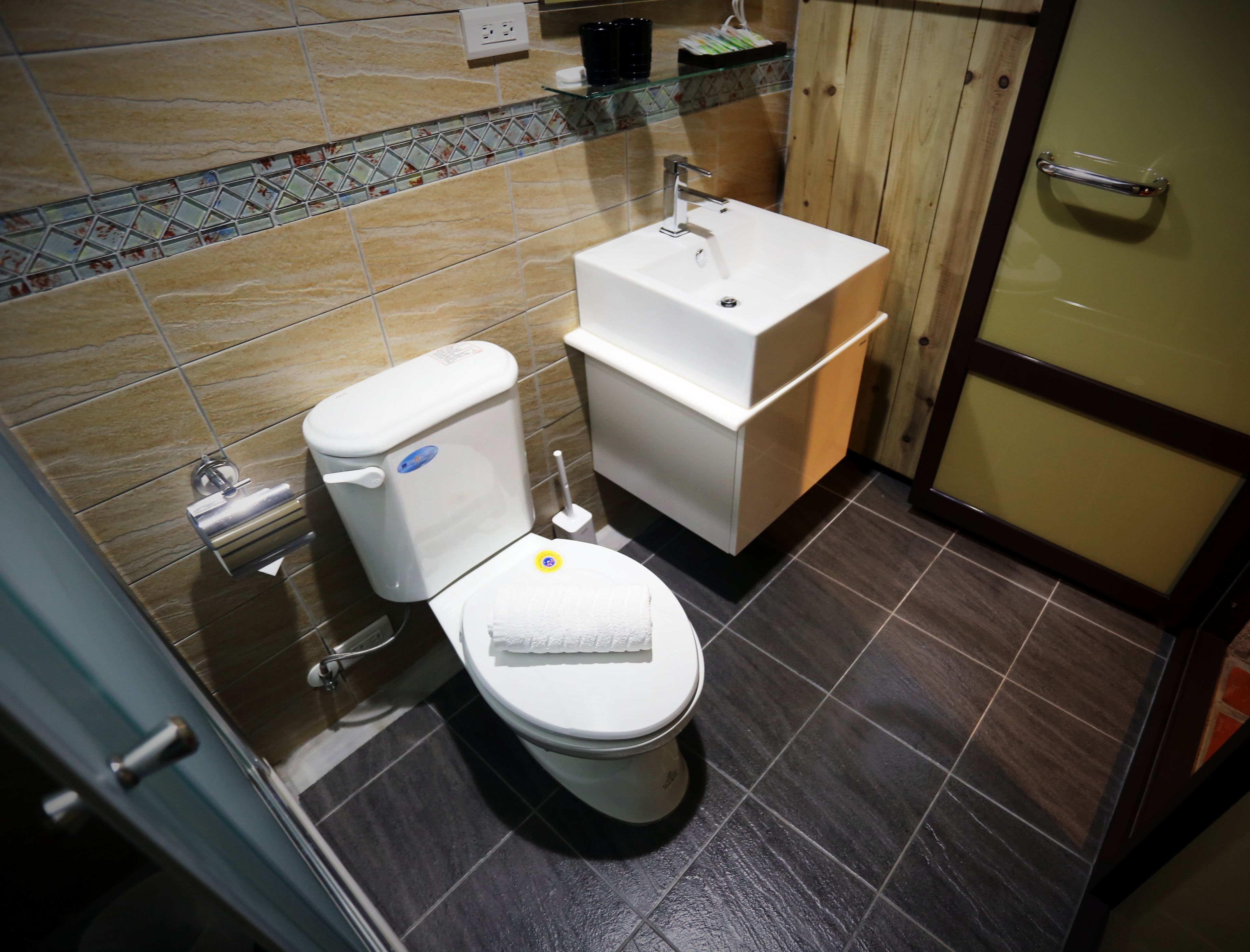 Un baño moderno con inodoro, lavabo y mueble de madera.