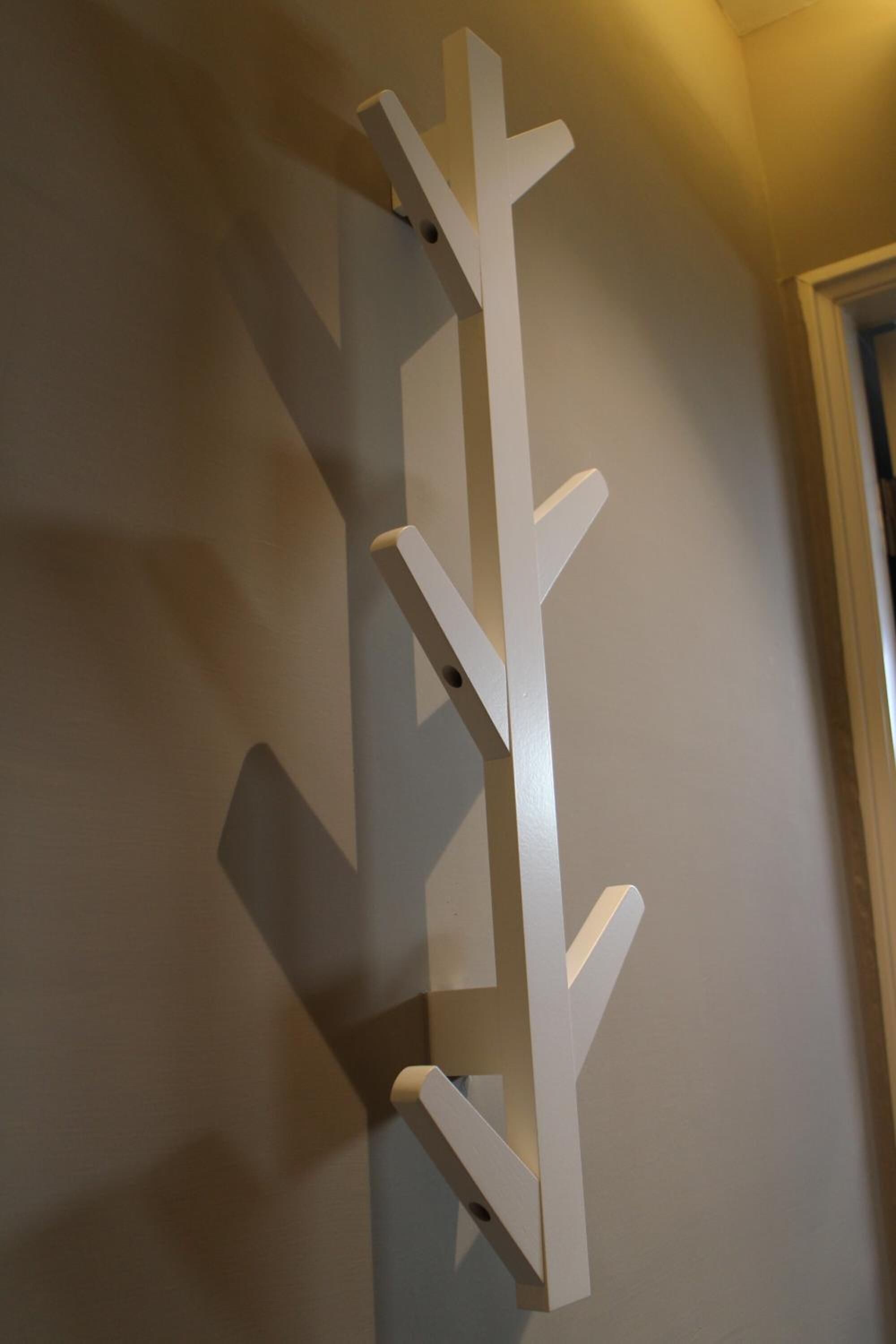 A white, abstract wall art piece with a vertical, branching design.