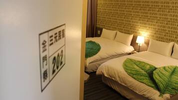 Quarto de hotel com duas camas, colcha com padrão de folhas verdes, parede com desenho em mosaico e um letreiro com caracteres japoneses.