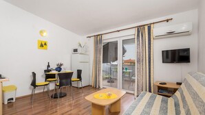 A compact living space with a kitchenette, a dining area, a sofa, and a TV. - 1 bedroom amazing apartment in Mandre (Mandre)
