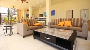 A spacious living room with two sofas, a coffee table, ceiling fans, and large windows. - Line In B&B (Jinhu)