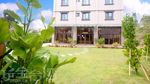 A modern building with a flat roof, large windows, and a covered entrance. - Line In B&B (Jinhu)