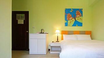 Una habitación de hotel con una cama, una mesita de noche, un escritorio y un cuadro en la pared.