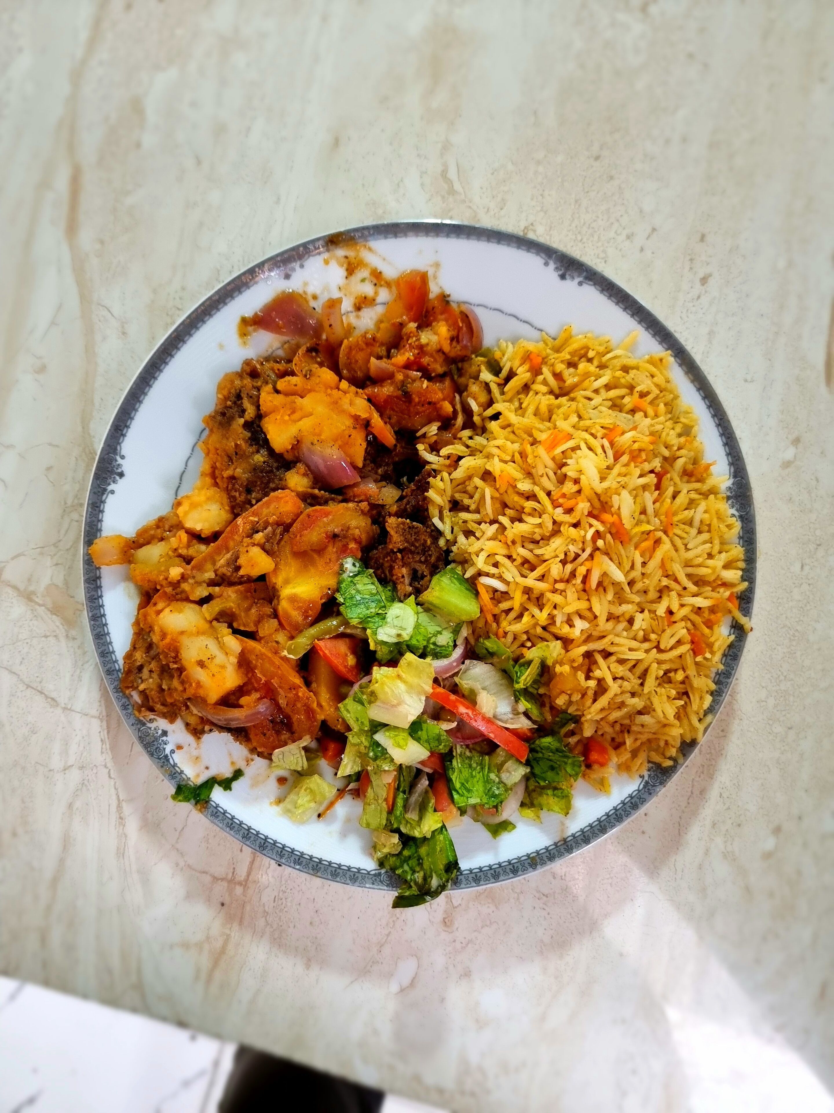 Un plato de comida con arroz, verduras y carne.