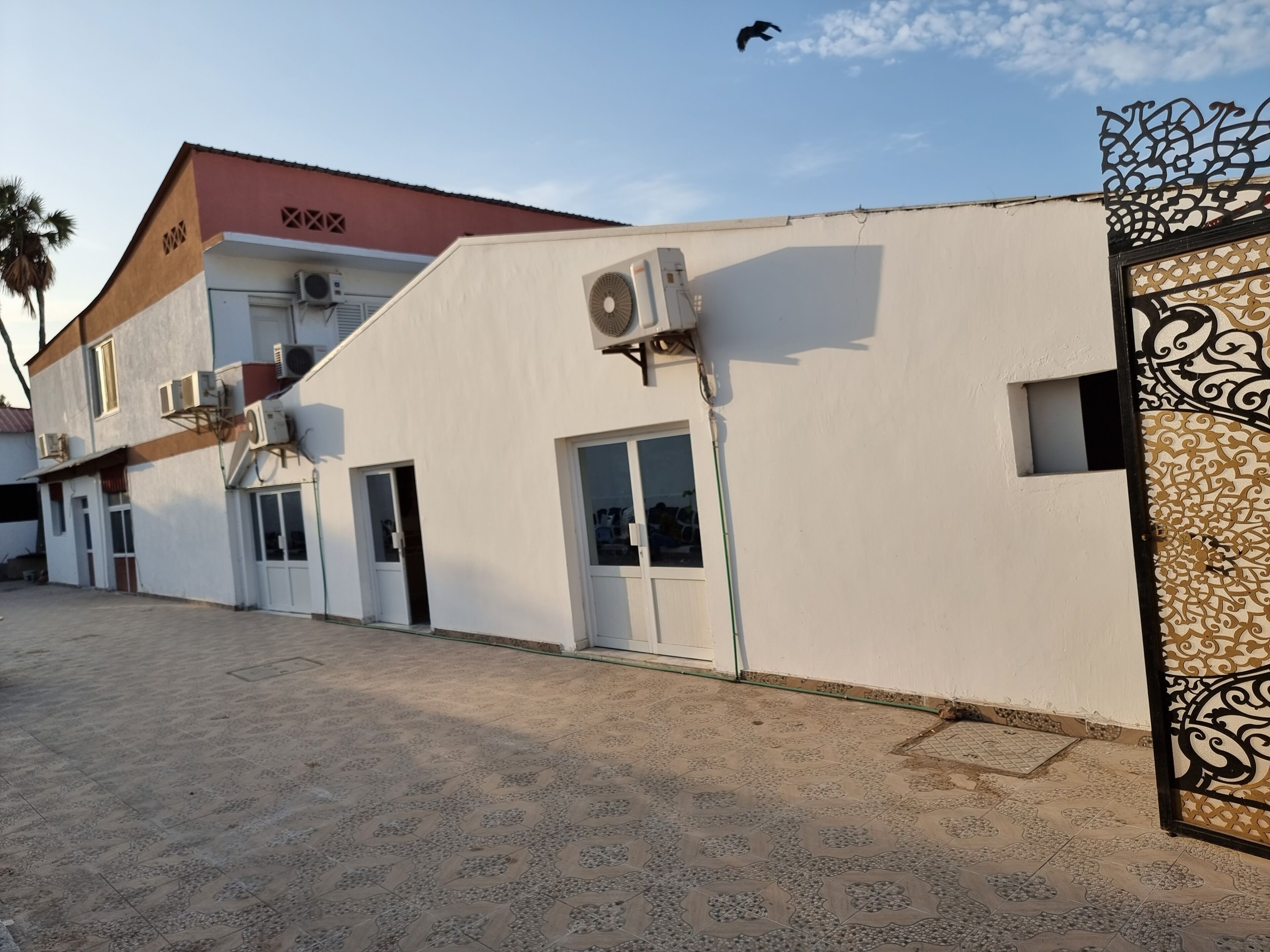 Un edificio con facciata bianca, diverse finestre e un condizionatore d'aria.