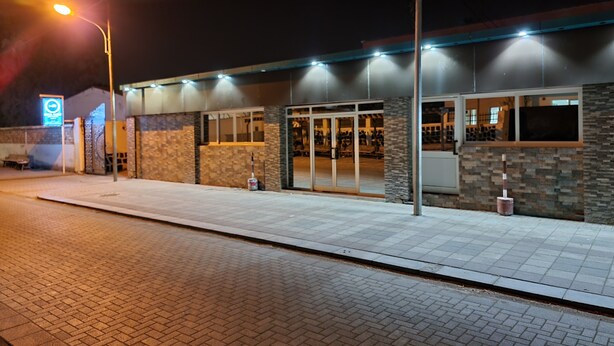 A building with a brick facade, large glass doors, and a sign indicating a business or service area. - Hotel Rayan Djibouti (Djibouti)