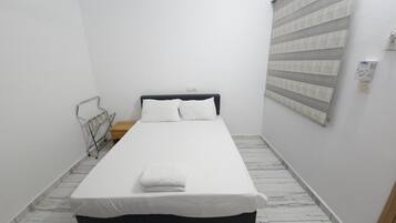Un dormitorio pequeño y ordenado con una cama individual, una mesita de noche y un radiador.