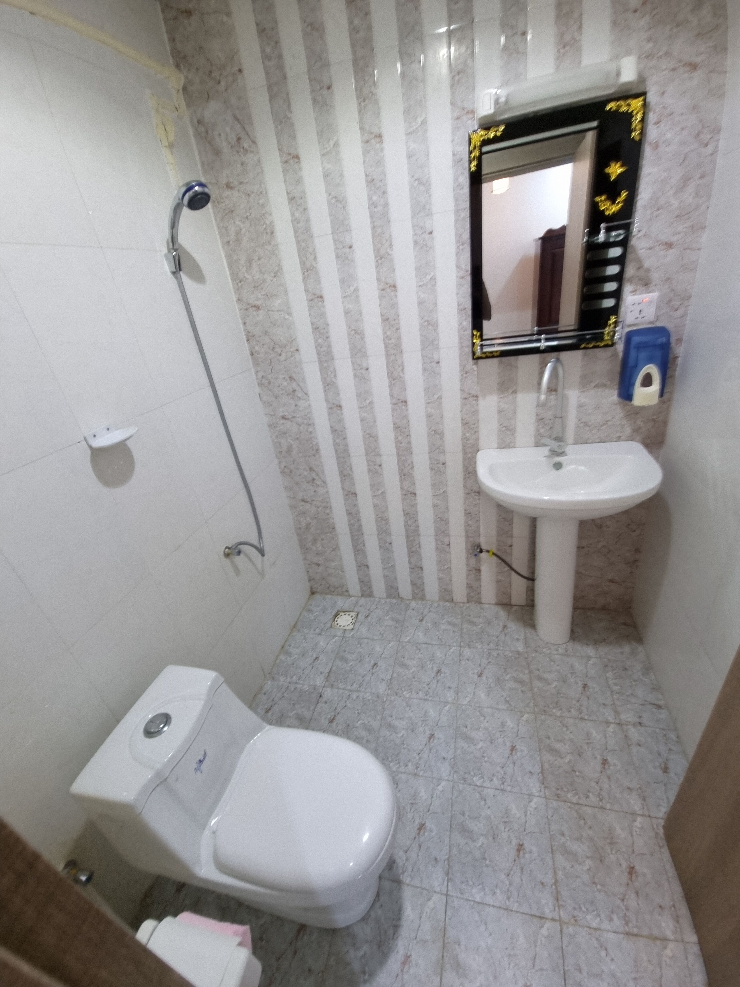 A bathroom with a toilet, sink, and shower.