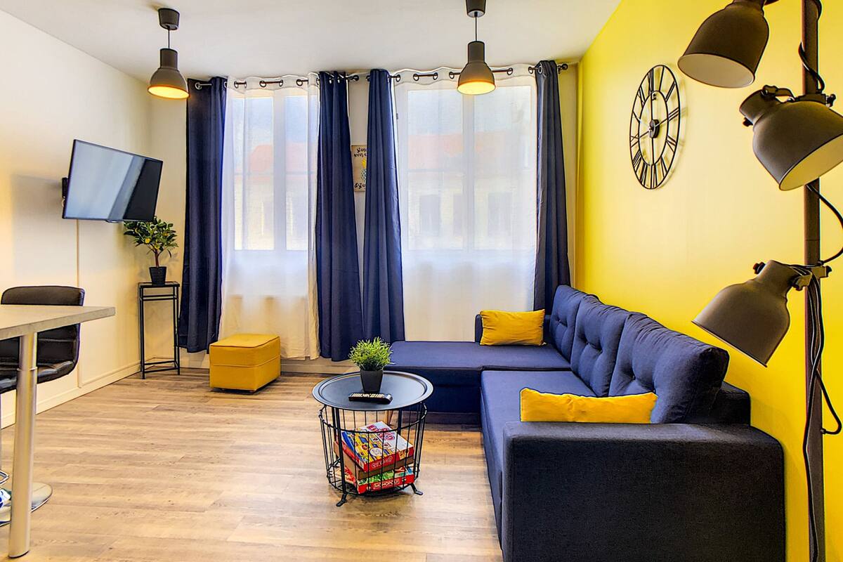 Un salon moderne avec un canapé, une table basse et un téléviseur.