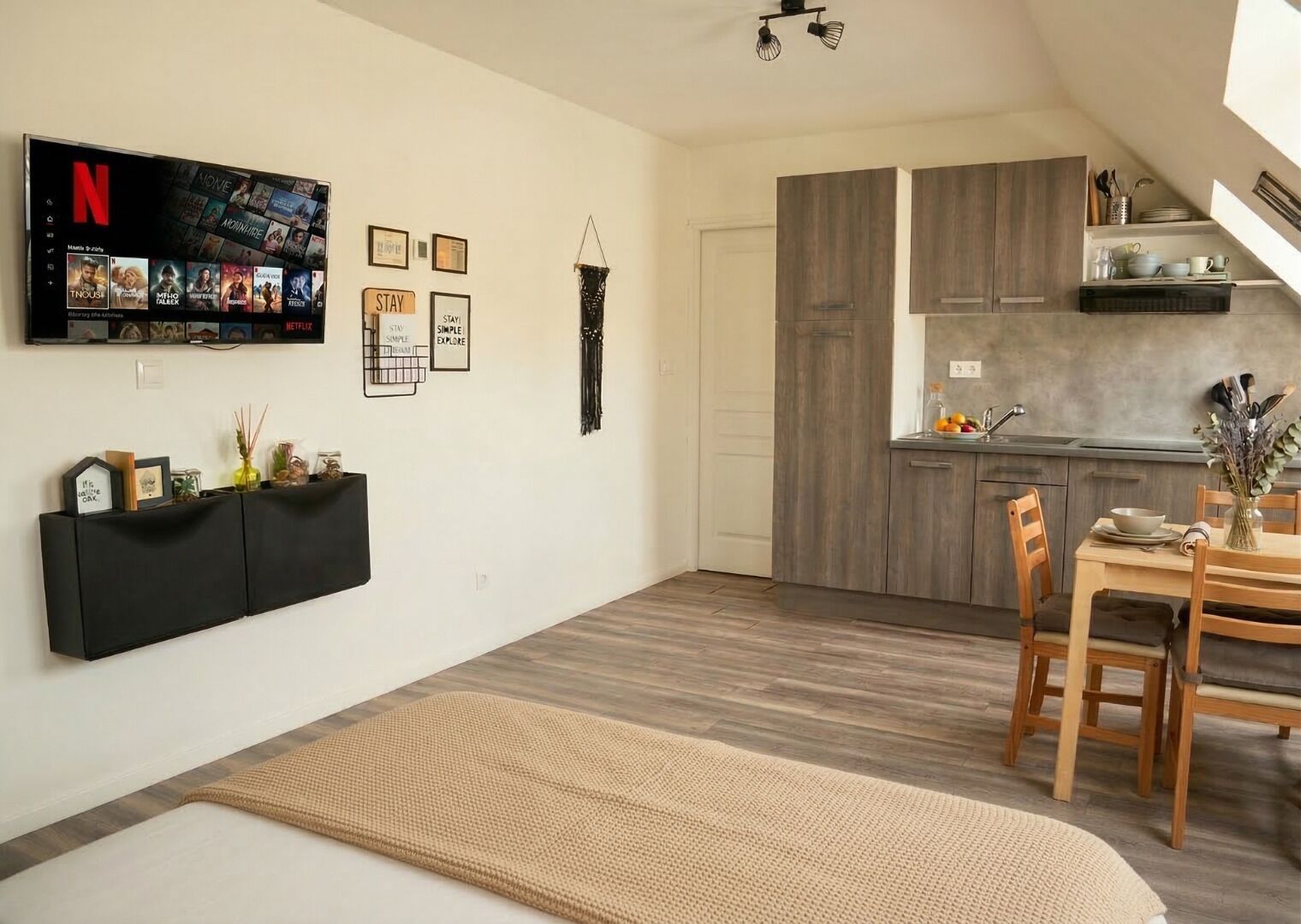 Ein stilvoller Wohnraum mit Flachbildfernseher, Essbereich und Küche.
