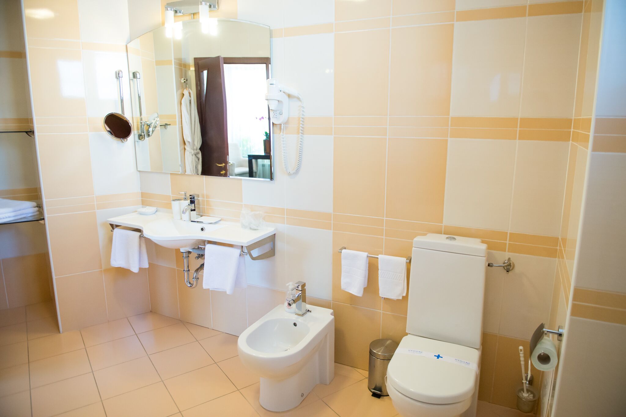 Une salle de bain équipée d’un lavabo, d’un bidet, de toilettes et d’un miroir.