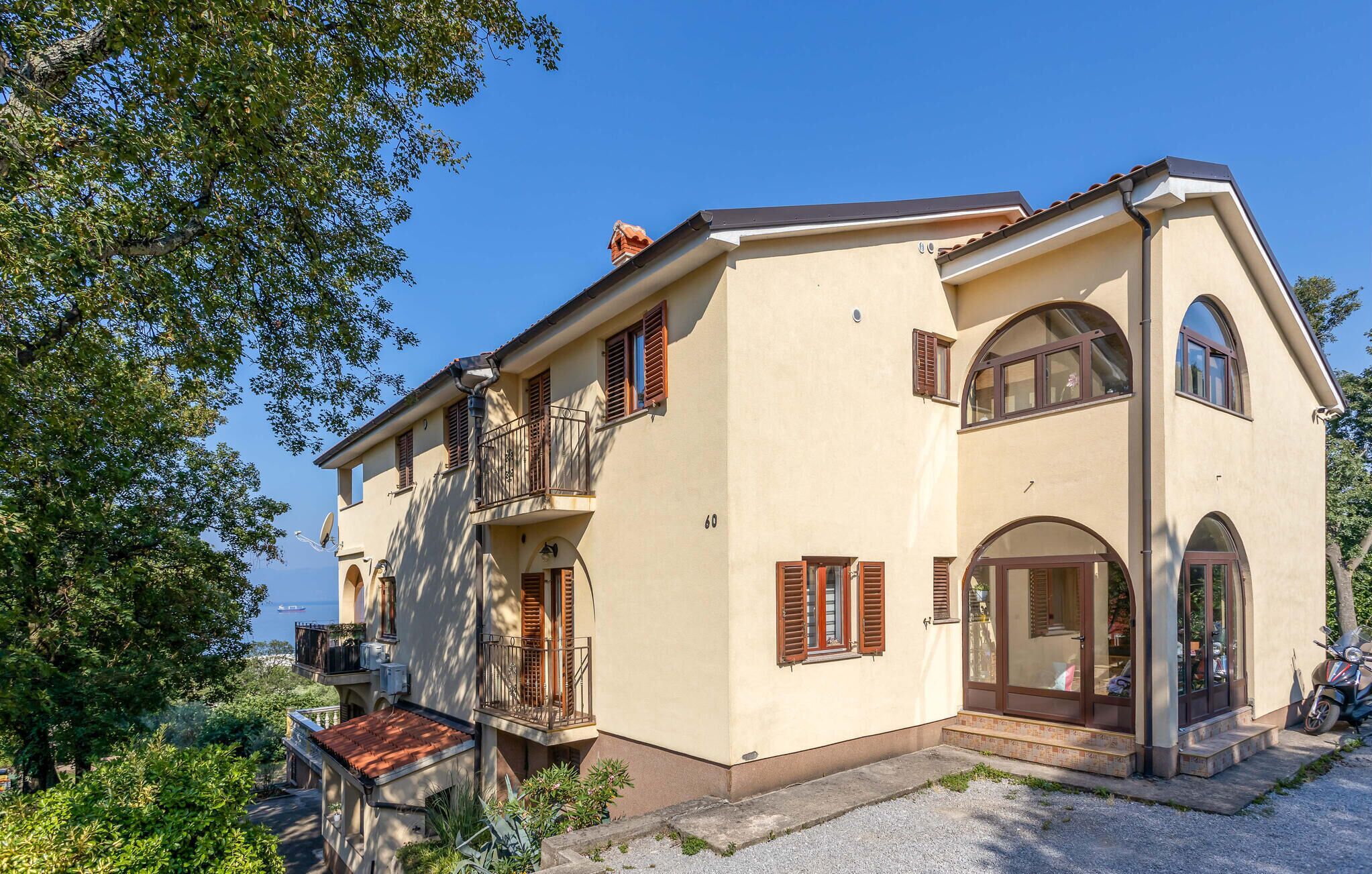 A two-story house with a balcony, a door with glass panels, and a satellite dish.