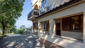 A building with a balcony, satellite dish, and air conditioning unit. - Beautiful apartment in Kostrena (Kostrena)