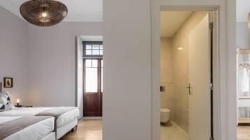 Un dormitorio con una cama grande, una lámpara colgante y vistas al baño.