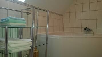 Bathtub, hair dryer, towels, toilet paper