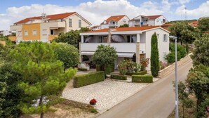 Un vecindario residencial con casas modernas, un camino de adoquinado y jardines bien cuidados.