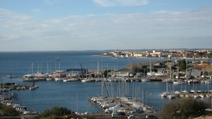 A marina with numerous boats docked, a clear sky, and a distant town. - Architect house with pool near the sea (Sète), WiFi, Climate, Clévacances 4Clés (Balaruc-les-Bains)