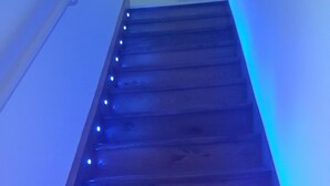 Eine Holztreppe mit blauen LED-Leuchten an den Stufen.