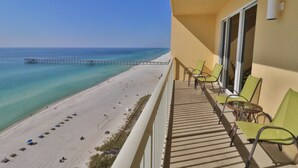 Een balkon met uitzicht op een strand en een pier.