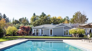 Una piscina con una casa al fondo.