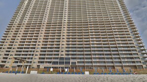 A high-rise building with multiple balconies and a uniform facade.