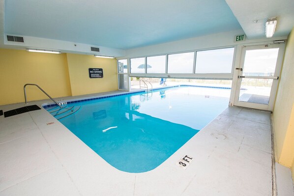 Una piscina interior con un cartel de 'No Diving', una escalera de piscina y una marca de profundidad de '3 FT'.