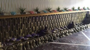 Una escalera de mármol con barandilla decorativa y una pared con líneas verticales.