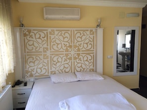 Simple, functional design with a single bed, bedside table, and decorative headboard.