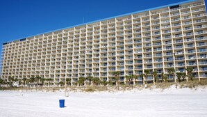 A large hotel with multiple floors and balconies, located near a beach with sparse vegetation. - Summit 1 BR SLEEPS 5  ***BEACH CHAIRS INCLUDED*** (Panama City Beach)