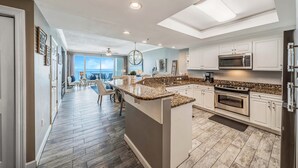 Una cocina moderna con una isla central, electrodomésticos integrados y vistas al exterior.