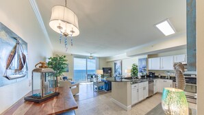 Una cocina amplia con electrodomésticos modernos, un comedor con mesa de madera y vistas al exterior.