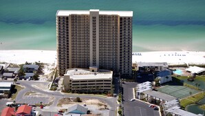 Un hotel de gran altura con varios pisos, un aparcamiento y vistas a la playa.