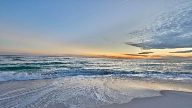 Una platja amb onades i un capvespre.