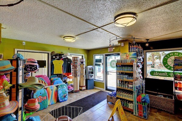 A store interior with shelves of hats, a cash register, and a window displaying a beach scene.