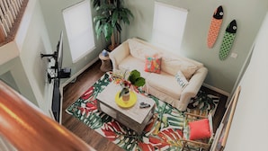 Un salon chaleureux avec un canapé, une table basse et une grande plante.