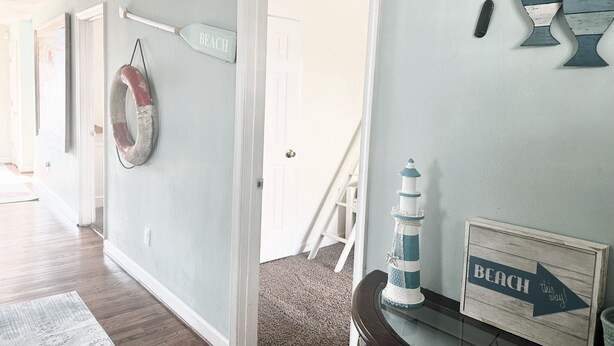 Un couloir avec une pancarte indiquant « LA PLAGE » et une bouée de sauvetage accrochée au mur.