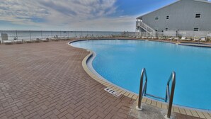 A swimming pool with a brick deck, a metal railing, and a building with a staircase. - Tidewater 1011 10th Flr 2BR+Bunks 3BA Early Booking Discounts 2 Beach Chairs (Panama City Beach)