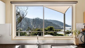 Une cuisine dotée d’une grande fenêtre donnant sur un paysage montagneux.