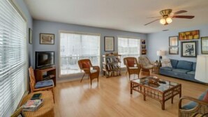A living room with a television, bookshelves, a coffee table, and a sofa.